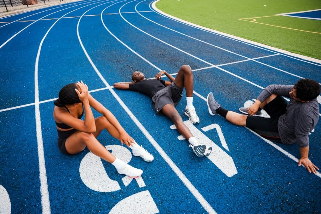 Atletas descansando tras una carrera en una pista de atletismo